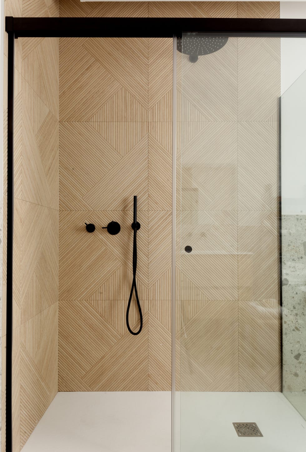 ducha de obra revestida con paneles de madera geométricos