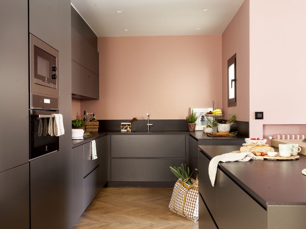 cocina moderna de color negro con isla central y pared rosa