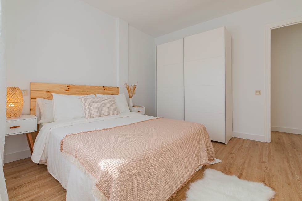 dormitorio de estilo nórdico con cabecero de madera