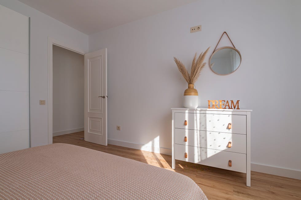 dormitorio de estilo nórdico con cabecero de madera