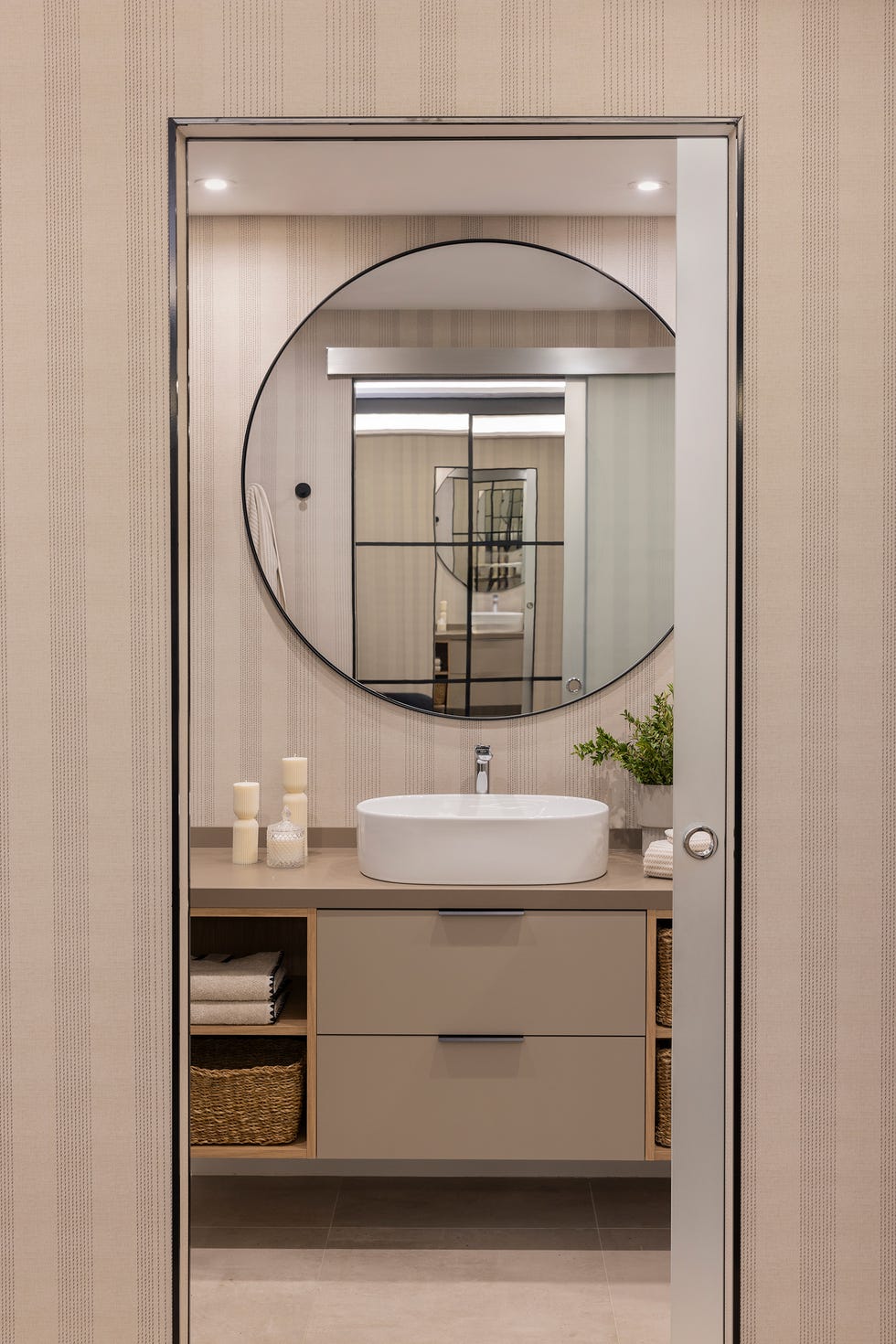 baño con mueble volado en color topo y papel pintado a rayas