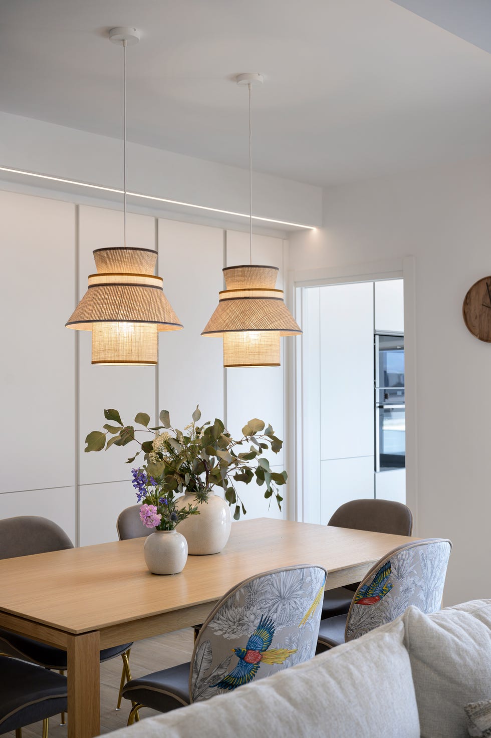 mesa de comedor de madera, sillas con tapizado exótico y lámparas de fibras