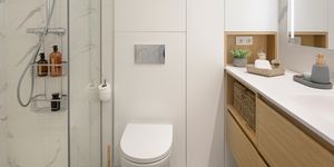 baño moderno con estantería blanca y mueble bajolavabo de madera volado