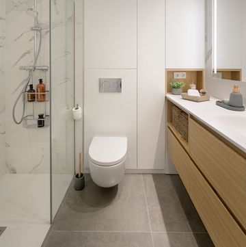 baño moderno con estantería blanca y mueble bajolavabo de madera volado