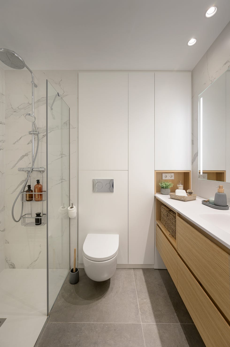 baño moderno con estantería blanca y mueble bajolavabo de madera volado