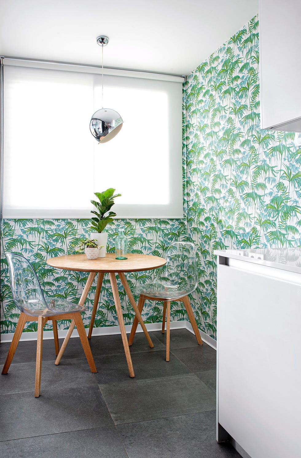 cocina moderna con armarios lacados blancos sin tiradores y office decorado con papel pintado exótico