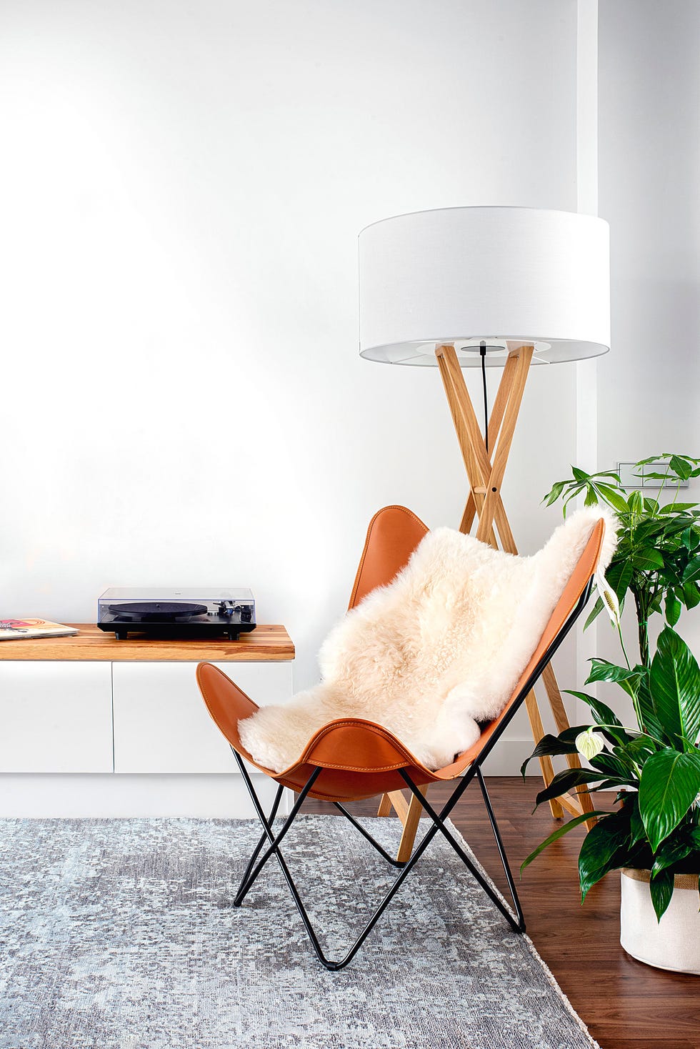 silla butterfly y lámpara de pie de madera con pantalla blanca