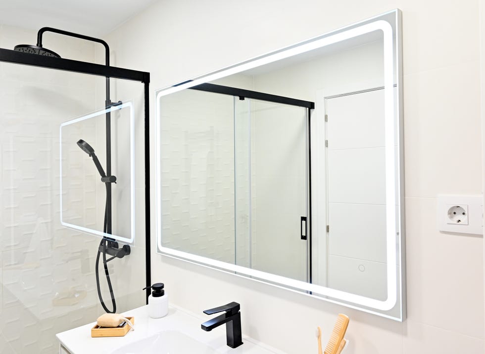 baño con ducha, grifo negro y espejo con luz integrada