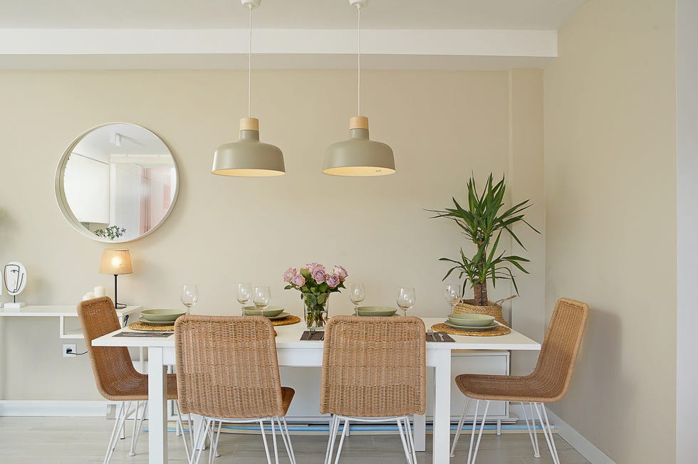 mesa de comedor blanca extensible y sillas de ratán