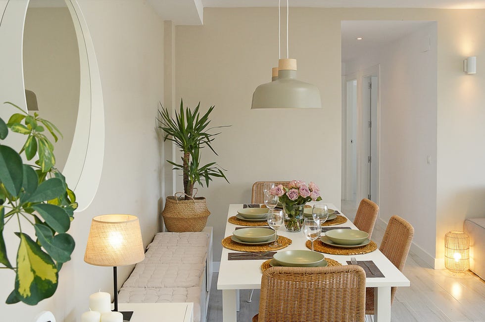 mesa de comedor blanca extensible y sillas de ratán
