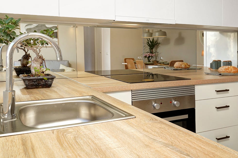 cocina con armarios blancos y encimera de madera
