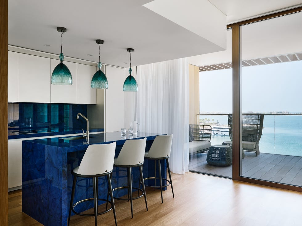 cocina abierta con armarios blancos e isla central azul índigo