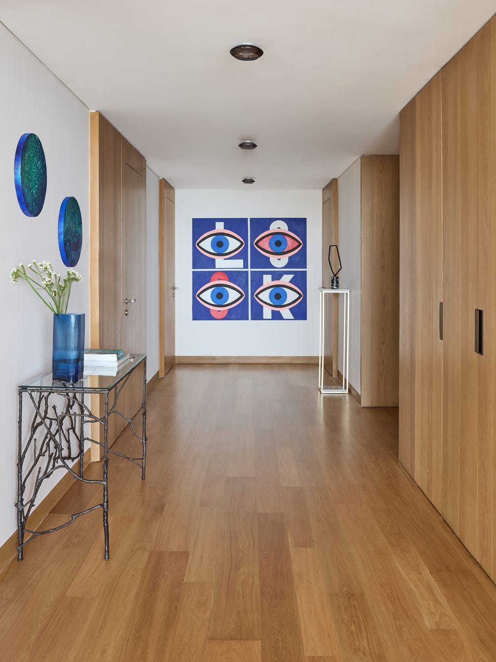 recibidor con armarios de madera y cuadro en la pared