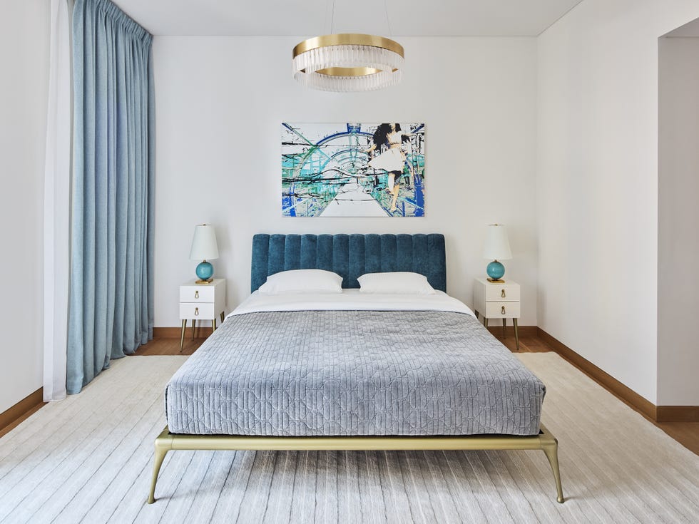 cama con base dorada y cabecero de terciopelo azul