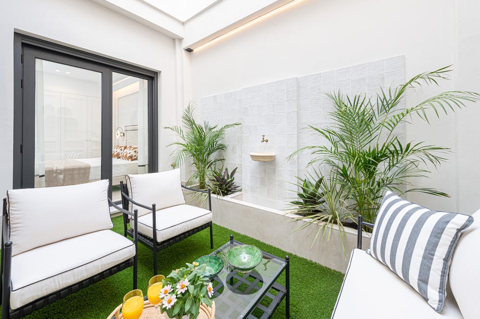 patio interior con sillones y fuente en la pared