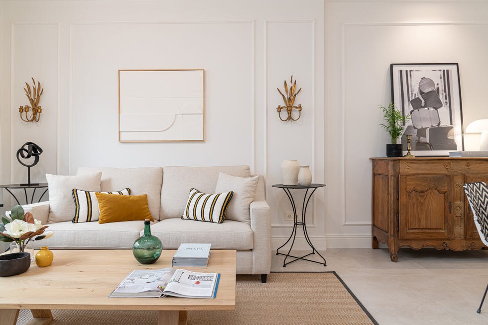 sofá beige, mesa de madera y pared con molduras