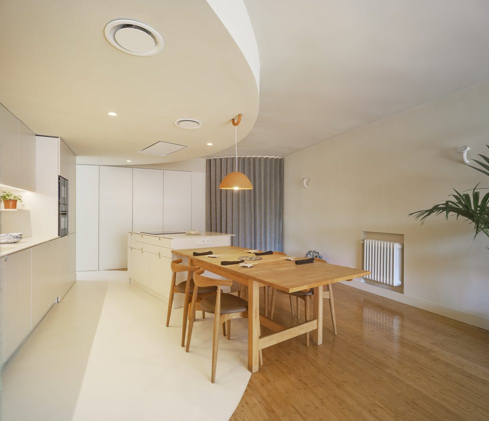 cocina abierta blanca con diseño moderno, isla central y office