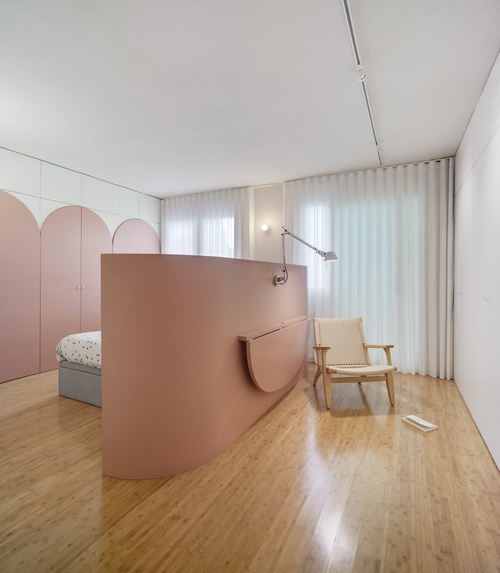 dormitorio moderno de color rosa con escritorio en la parte trasera del cabecero