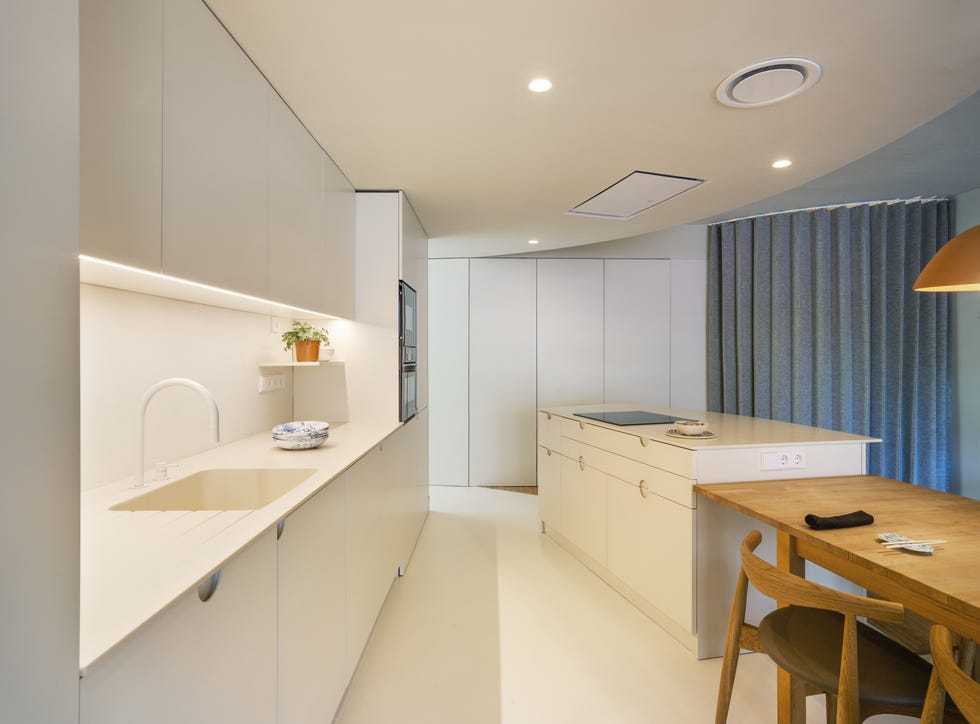 cocina abierta blanca con diseño moderno, isla central y office