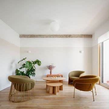 salón con butacas verdes y mesas de centro de madera