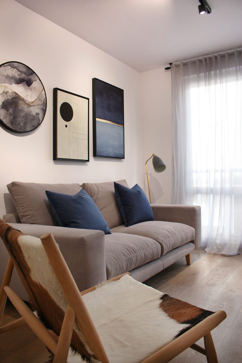 salón moderno con sofá gris y butaca de piel de cabra