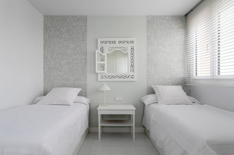 habitación con dos camas y papel pintado floral gris