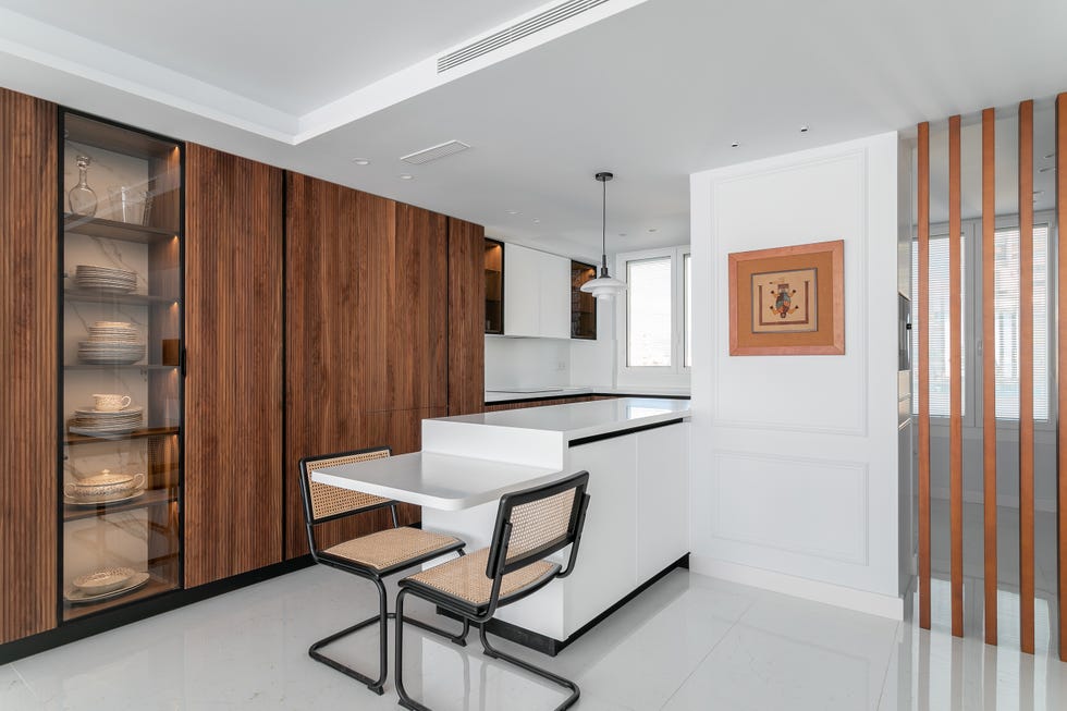 cocina blanca con isla y armario de madera con vitrina