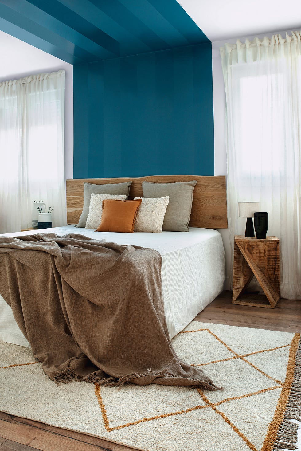 dormitorio moderno con cabecero y mesita de madera y alfombra kilim