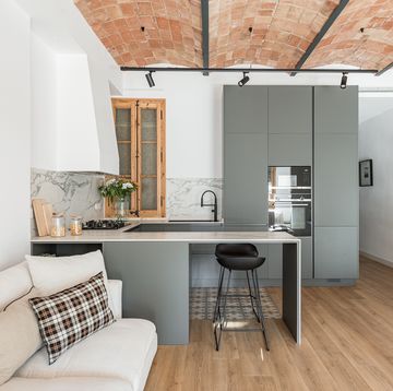 cocina de color gris abierta al salón con techo de bóveda catalana
