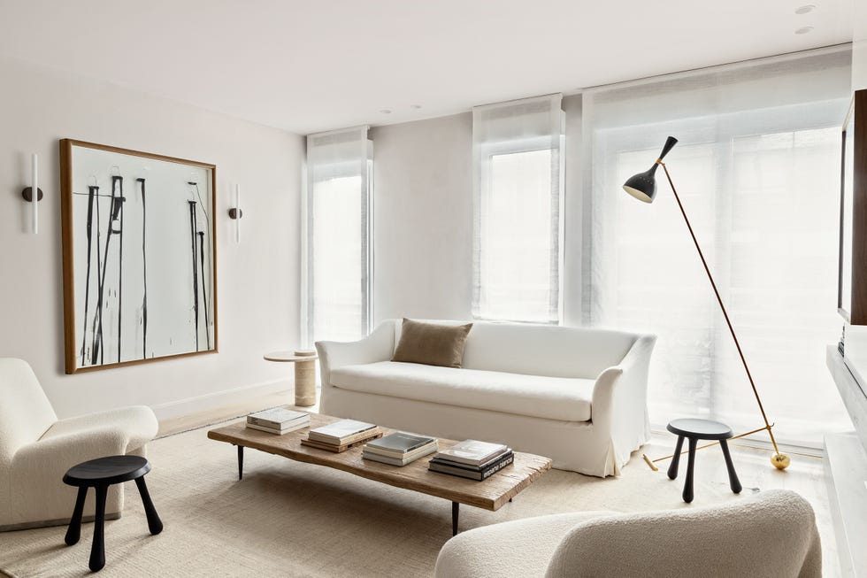 salón con sofá blanco de lino, butacas y mesa de centro de madera
