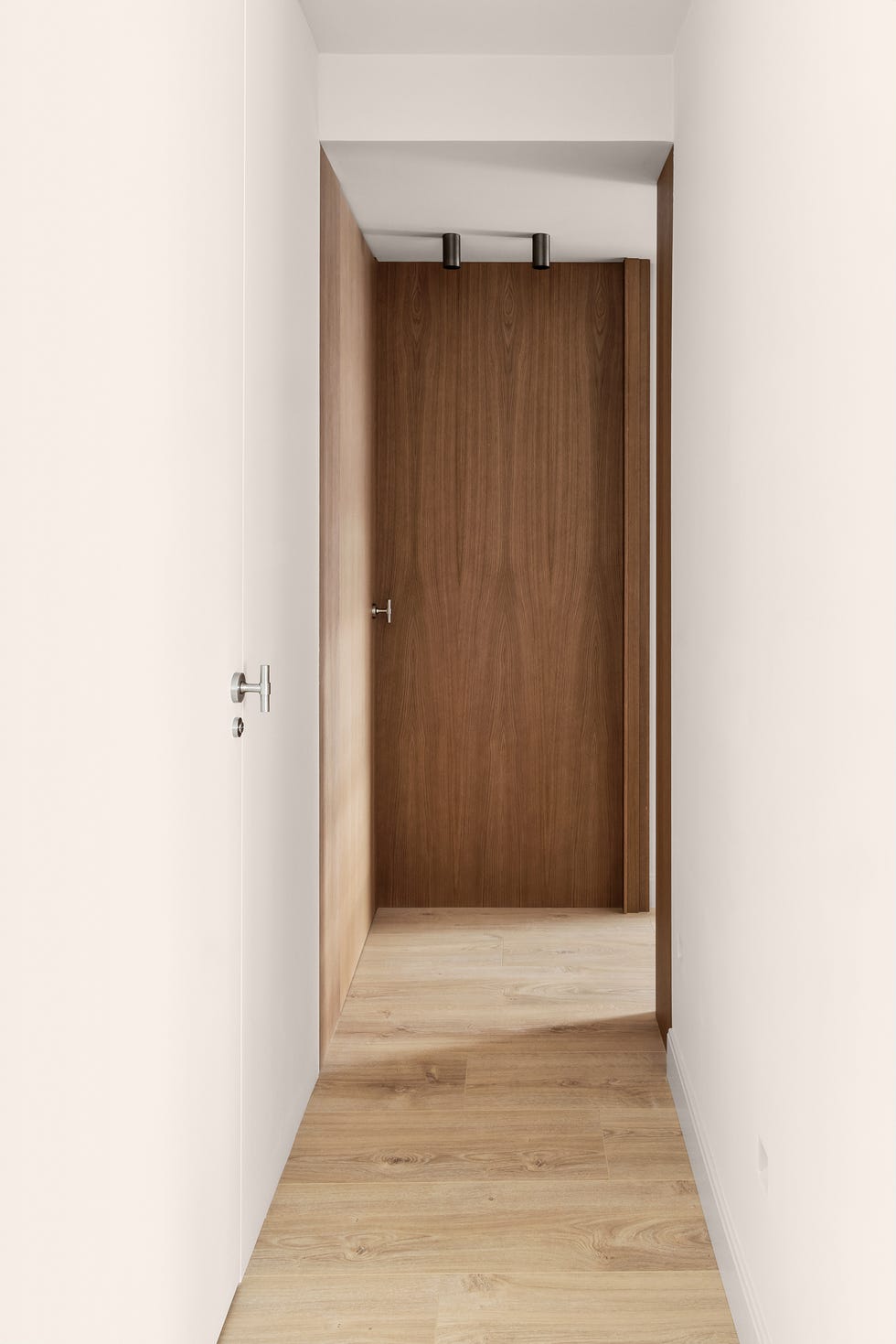pasillo con puertas y paredes en blanco y madera