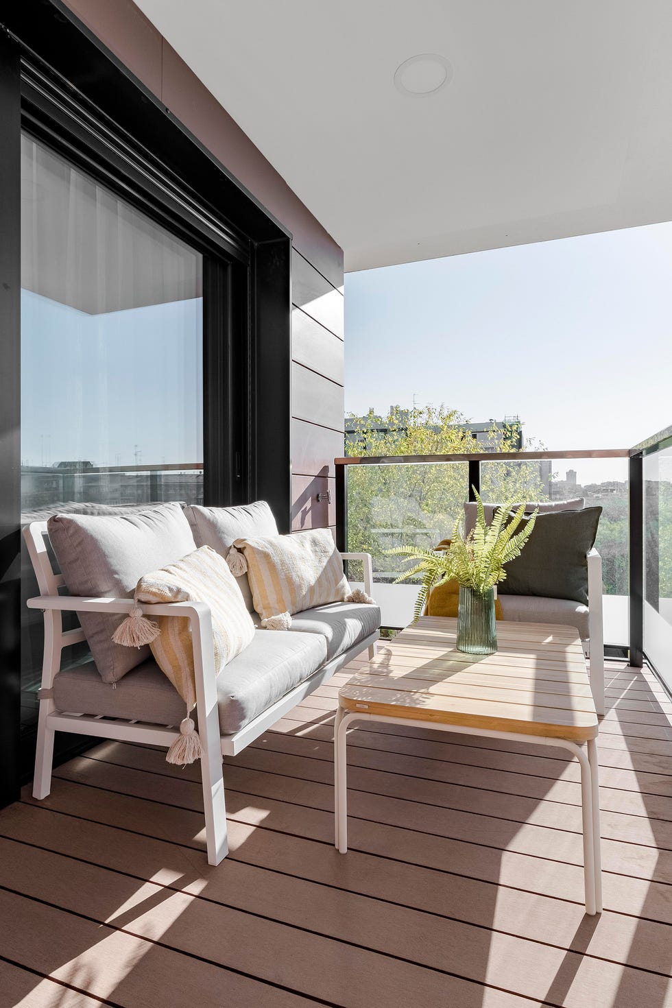 terraza con muebles de exterior sobre tarima de madera