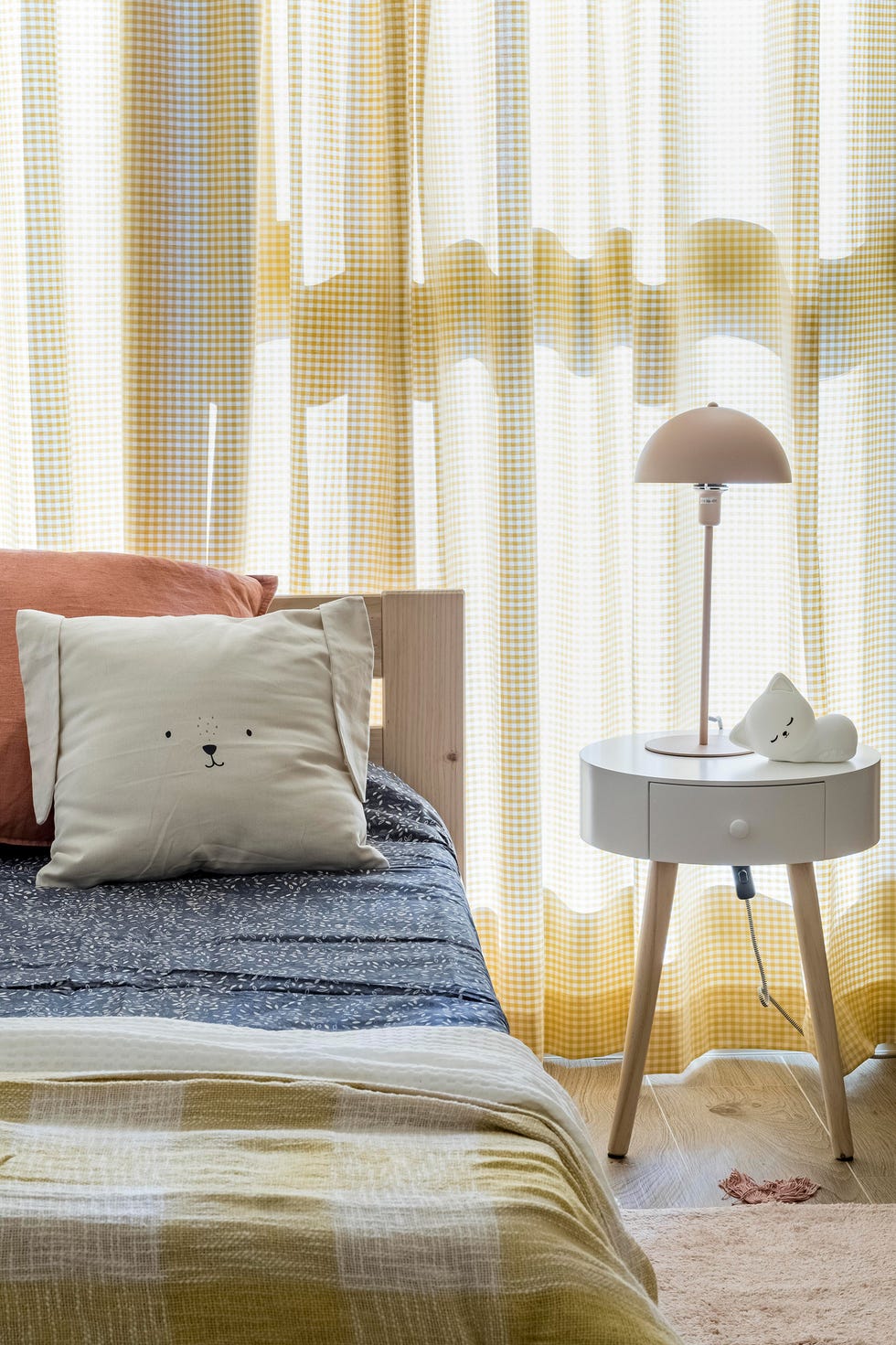 cama infantil de madera y mesita de noche blanca redonda