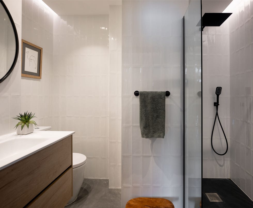 baño con ducha y azulejos blancos
