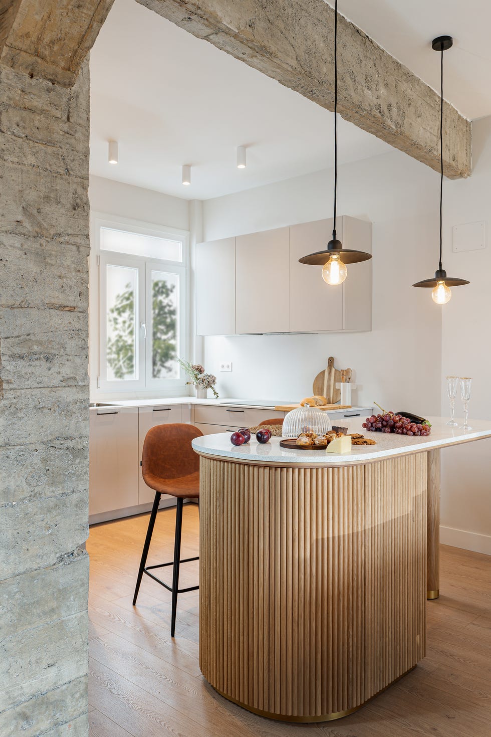 cocina abierta con isla realizada en madera con encimera de mármol
