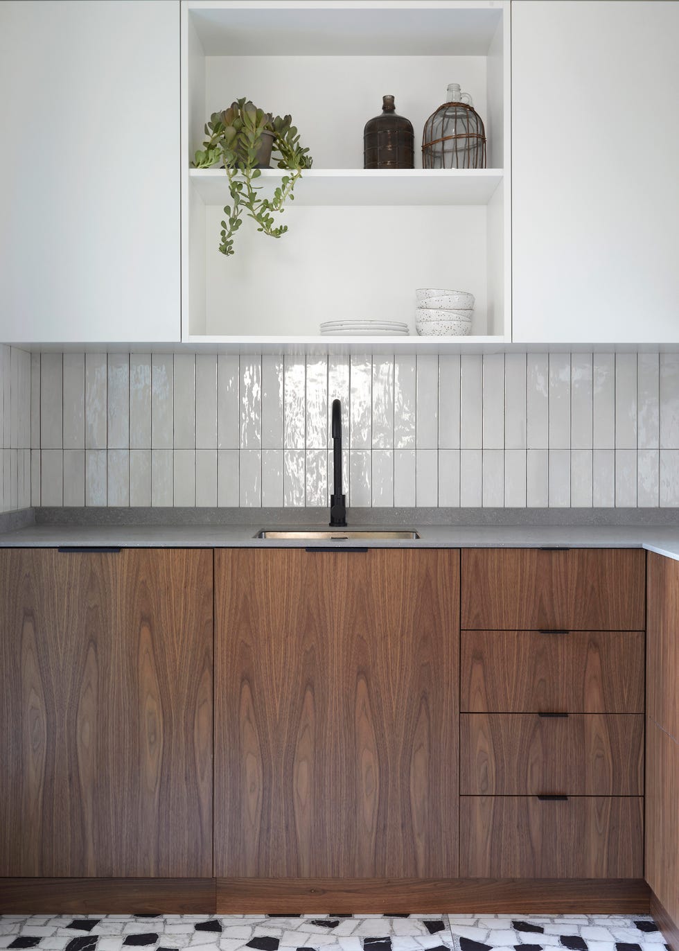 cocina con frentes de madera en los armarios, azulejos blancos y baldosas en blanco y negro