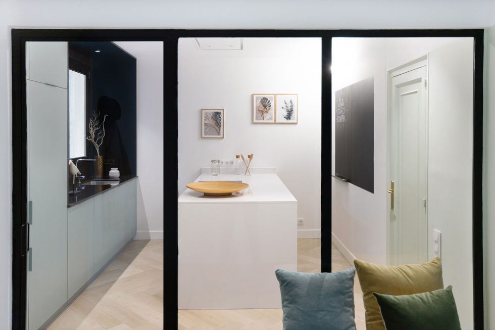 cocina blanca moderna con isla y cerramiento de vidrio