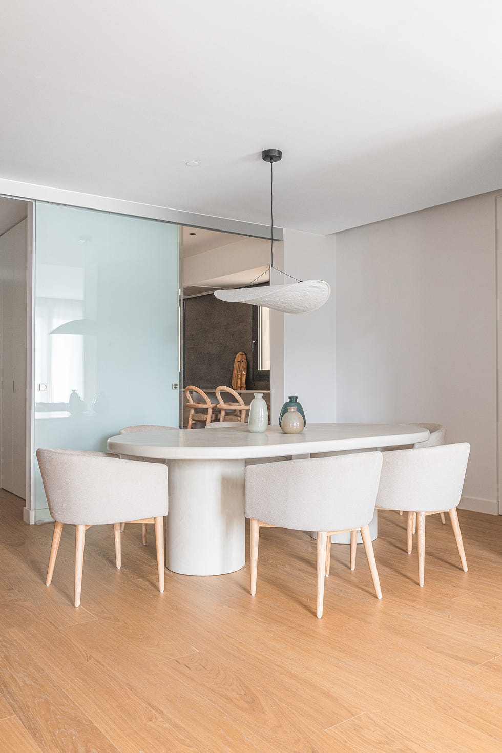 mesa de comedor ovalada de piedra con sillas beige