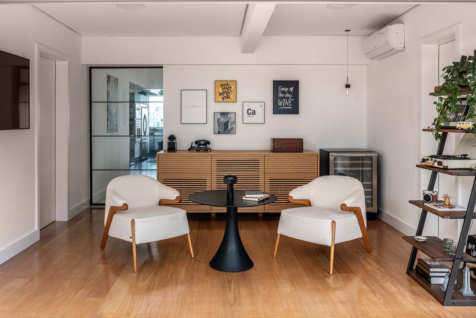 salón con dos butacas modernas tapizadas en beige y mesa tulip negra
