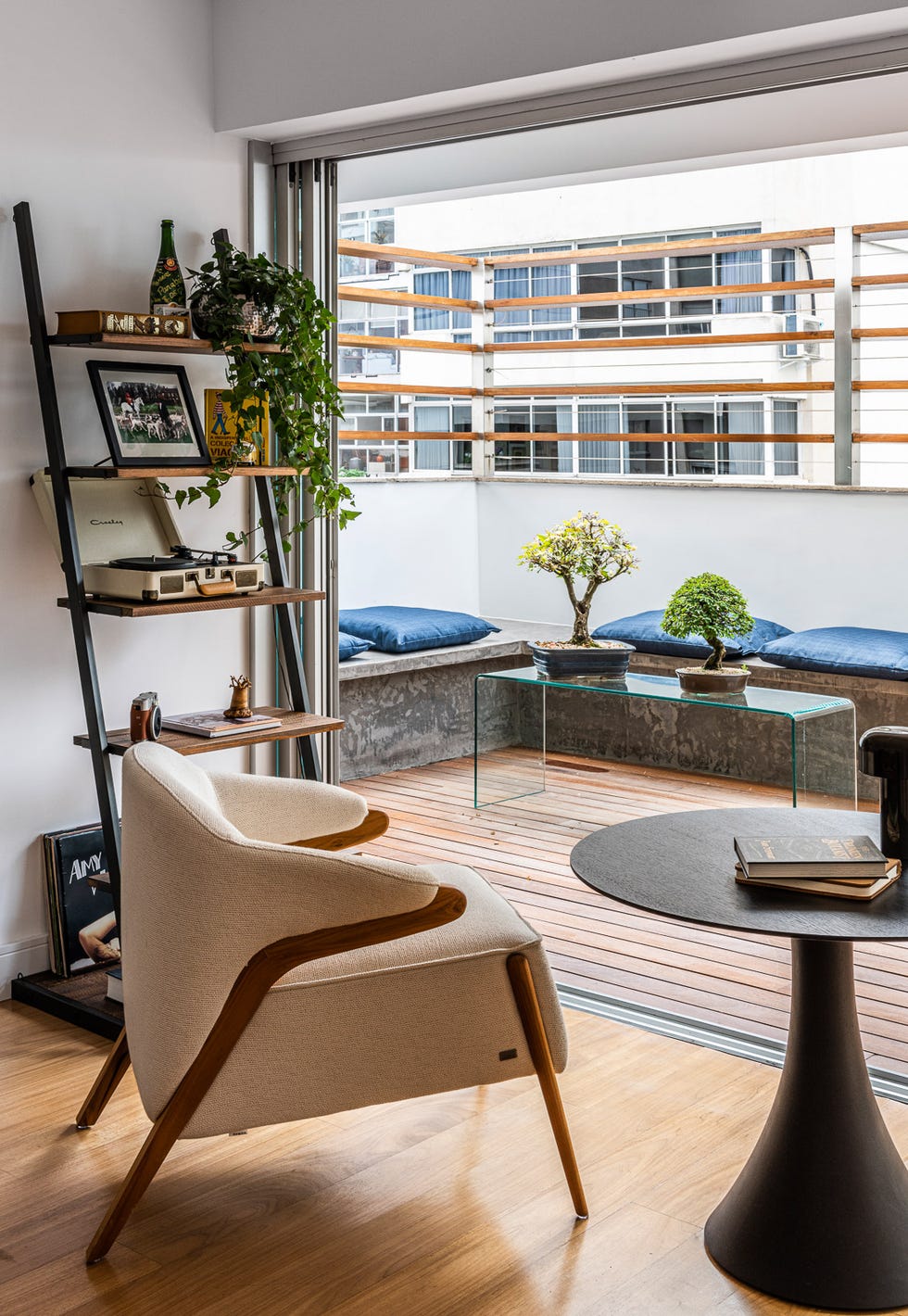 butaca moderna tapizada en beige con mesa tulip negra y vistas a la terraza