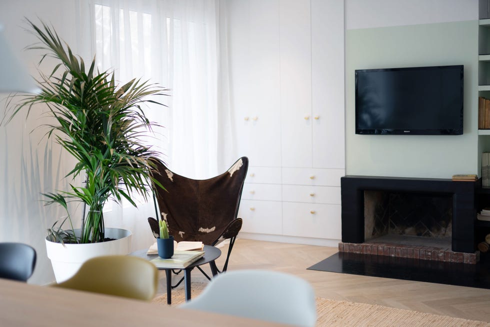 salón con chimenea y pared pintada en verde empolvado