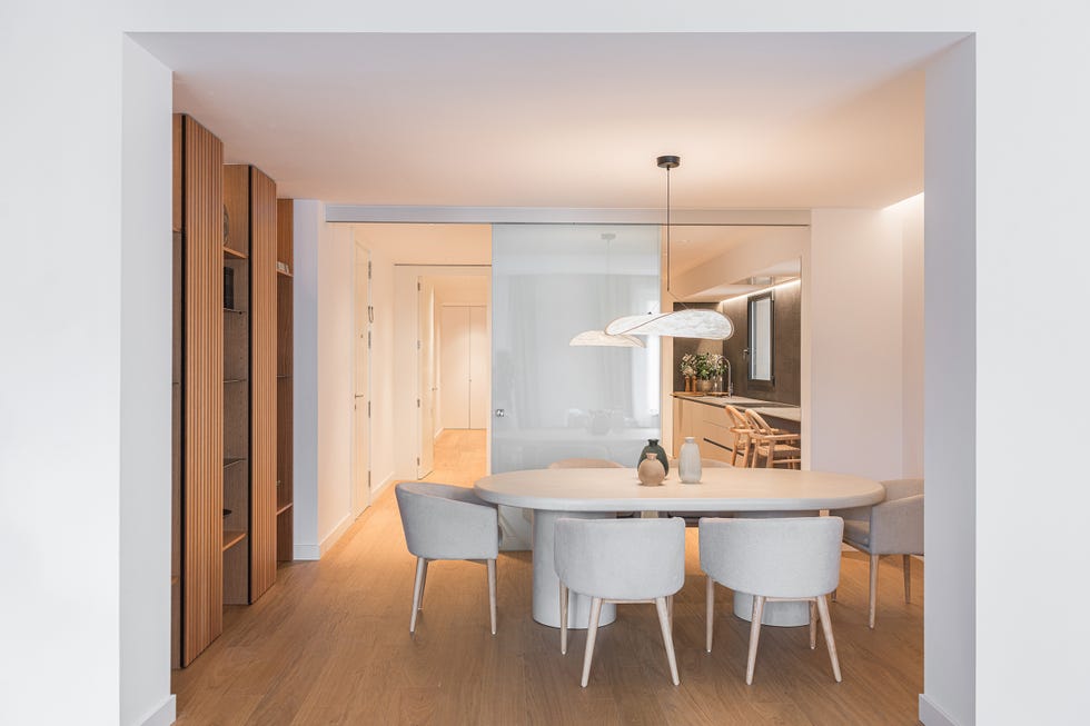 mesa de comedor ovalada de piedra con sillas beige