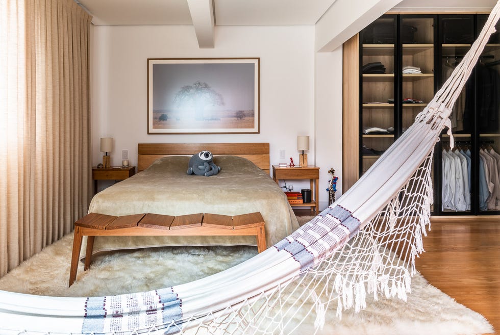 dormitorio moderno con cama de madera, vestidor y hamaca