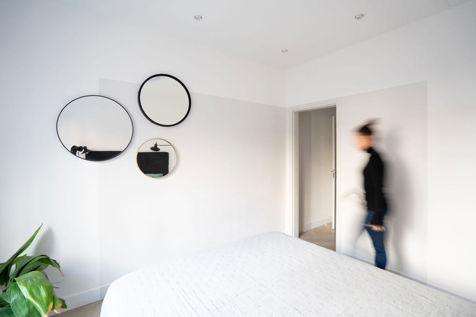 dormitorio minimalista con espejos redondos