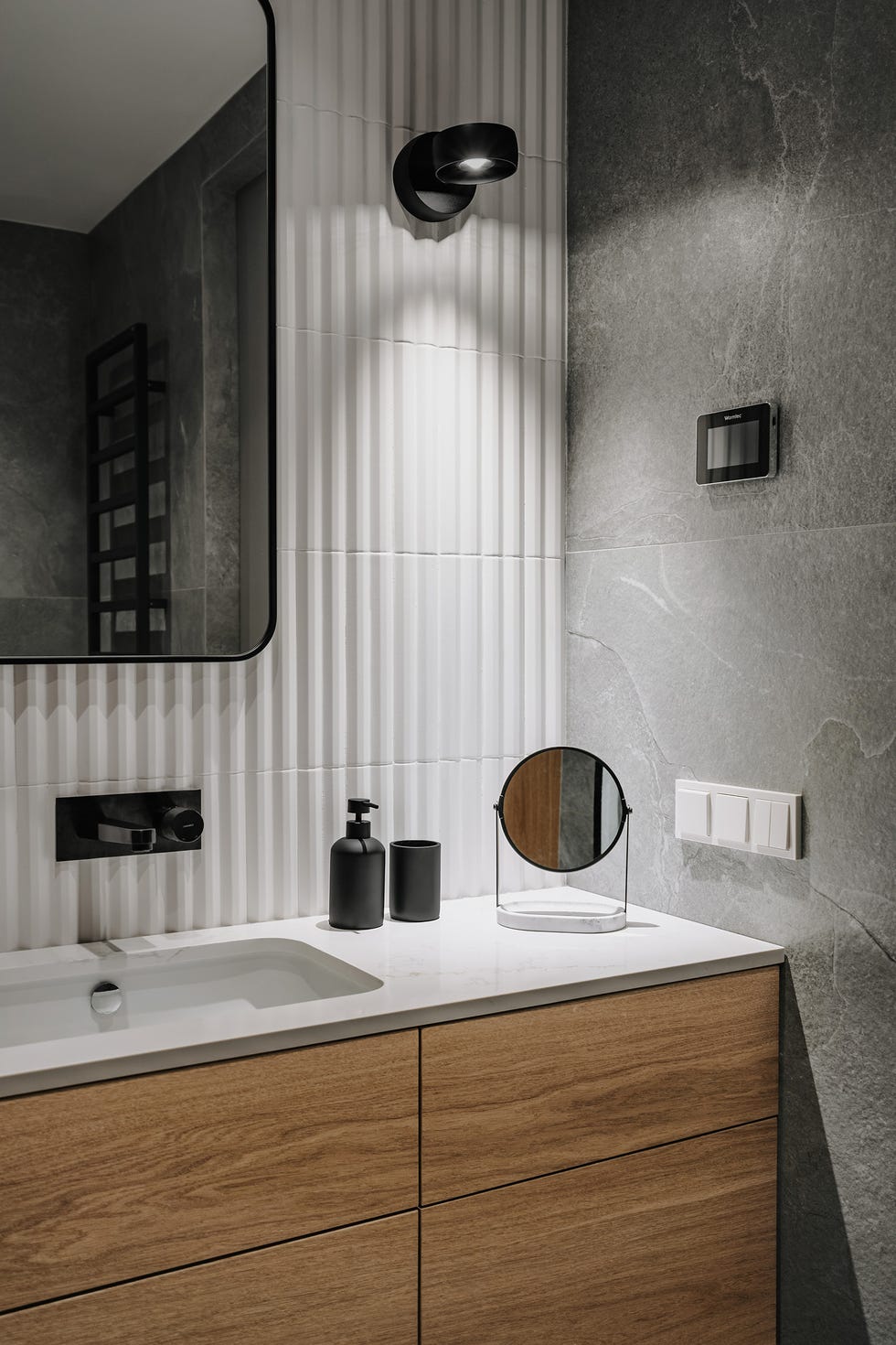 baño con azulejos blancos y mueble de lavabo de madera