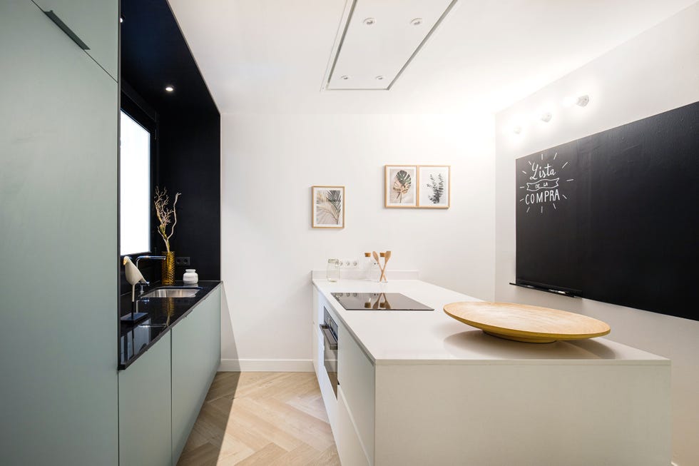 cocina moderna con isla, pared en negro y armarios azules