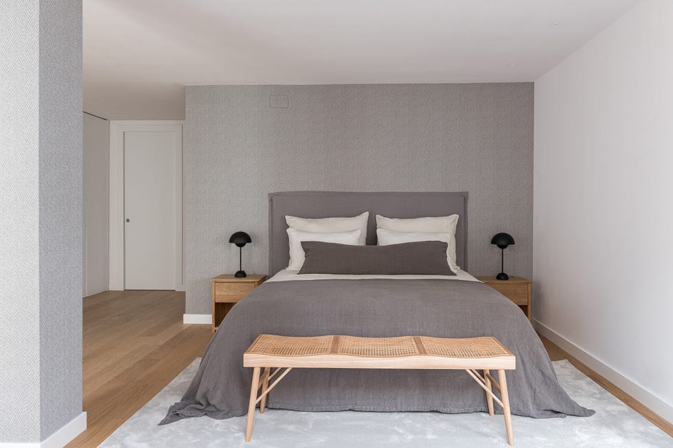 cama con cabecero de lino gris y banco a los pies