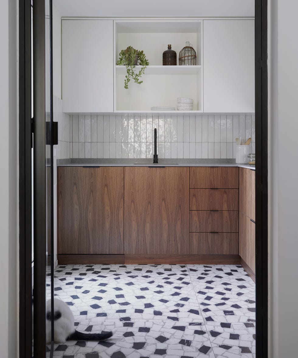 cocina con frentes de madera en los armarios, azulejos blancos y baldosas en blanco y negro