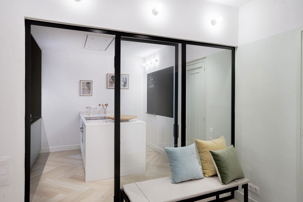cocina blanca moderna con isla y cerramiento de vidrio