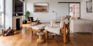 salón de diseño moderno con sofá con chaise longue beige y butaca con reposapiés de madera con cojines beige